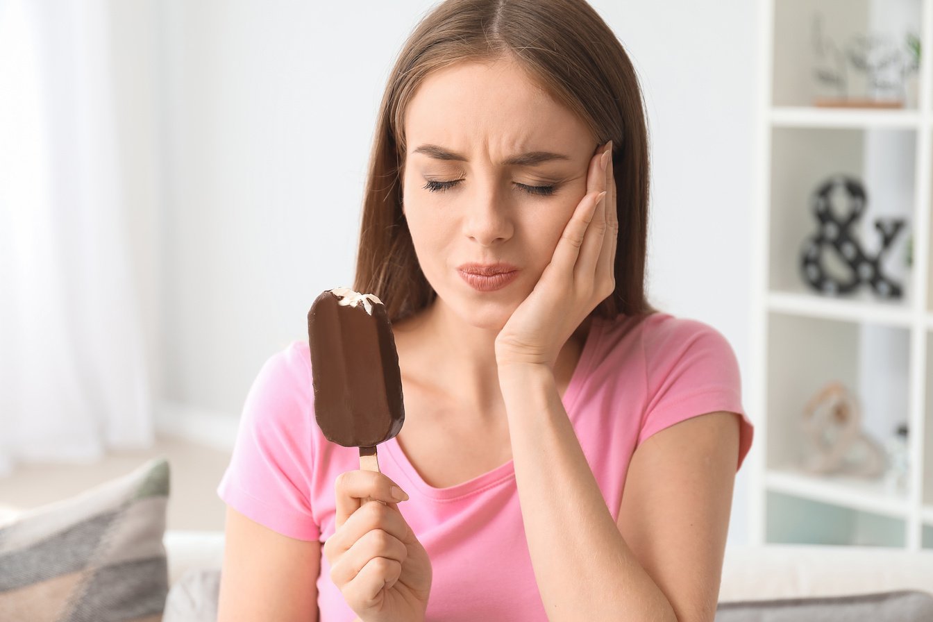 Young Woman with Sensitive Teeth and Cold Ice-Cream at Home